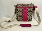 Bandolera Coach marrón firma con ribete rosa y herrajes plateados